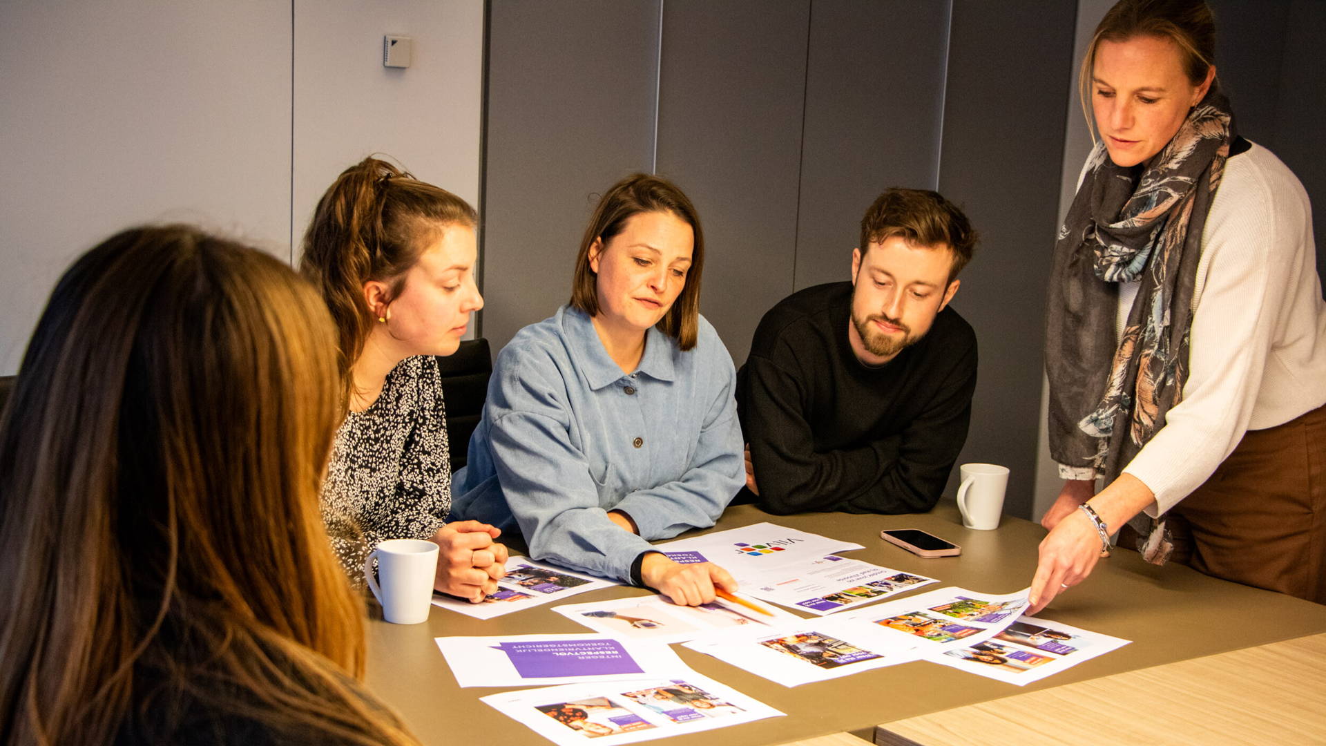 Medewerker Elke, Mart, Bran in gesprek met medecollega's tijdens brainstorm.
