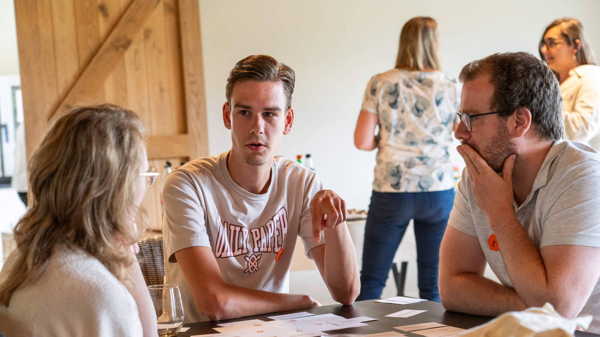 Medewerker Jeroen in gesprek met medecollega's tijdens een brainstorm.