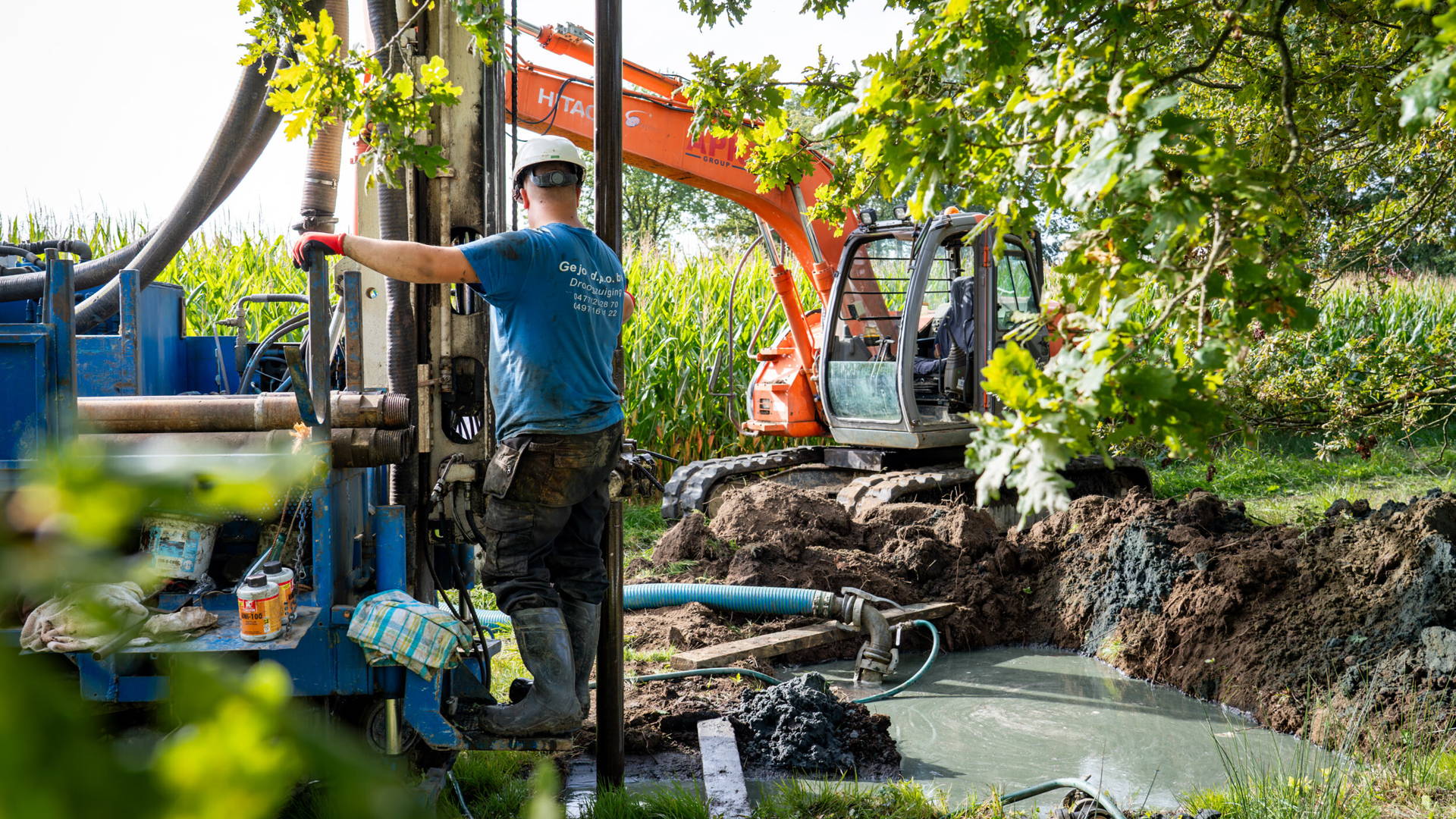 Aquafin installatie pompstation. Arbeider in werkkledij bestuurt machine.