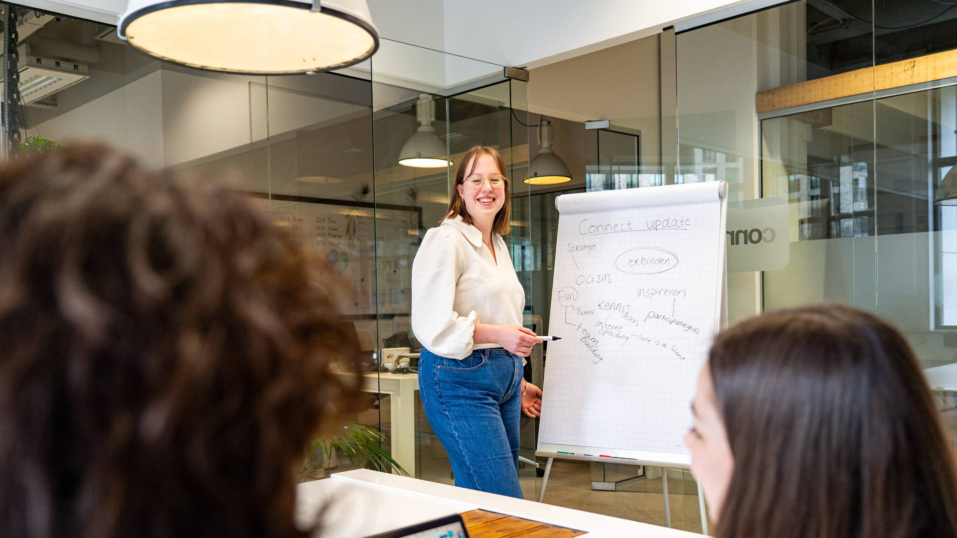 Medewerker Iris geeft een presentatie aan collega's.