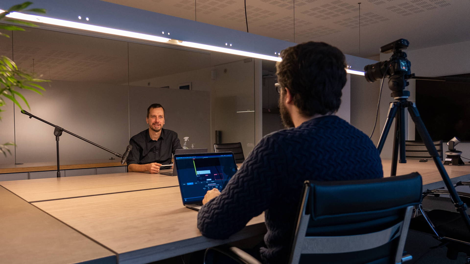 Medewerker Jan neemt een interview af en een vergaderzaal van Connect. Het wordt opgenomen met geluid en camera.